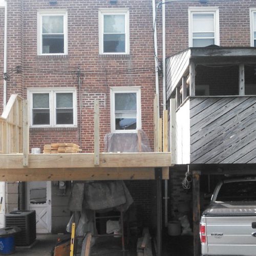 Construction of a wooden deck extension with a car underneath